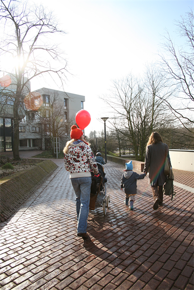 Dieses Bild zeigt eine Familie mit einem roten Ballon.