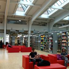 Lounge in der Hochschulbibliothek mit roten Sitzbänken und Tischen