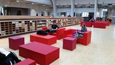 Lounge in der Hochschulbibliothek Lounge in der Hochschulbibliothek mit roten Sitzbänken und Tischen