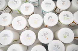 	
Abgebildet sind 21 verschiedene weiße, medizinische Plastikschraubdosen. Diese sind von oben fotografiert, sodass eine Aufsicht auf die Deckel gegeben ist. Auf diesen Deckeln befinden sich bunte Aufkleber, mit einfachen Icons die verschiedene Maßnahmen, um das Klima zu schützen, aufgeklebt sind. Sie stehen auf einem weißen Tisch.