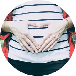 Pregnant woman forming a heart on her belly with her hands