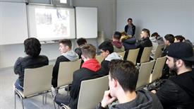 Boys are sitting in a Seminar room and listen to a presentation