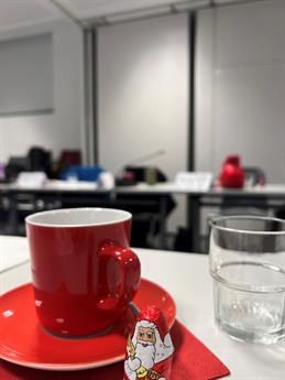In the photo there is a red coffee cup and a chocolate Santa Claus.