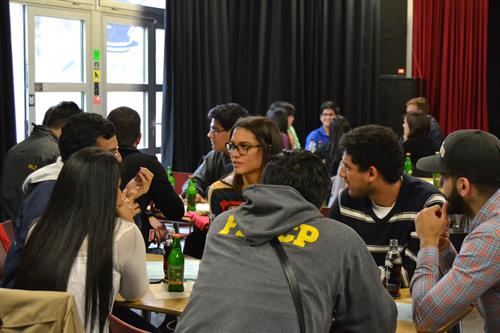 Studierende aus Deutschland und aus Ecuador sitzen an einem Tisch und unterhalten sich.