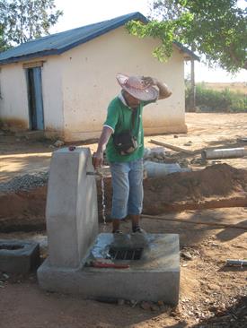 Prof. Romain Rabearisoa, Initiator and Director of the Project in the Village of Andalamengoke, tries the new well at the School.